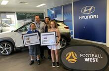 Tha Len Sui, front left, and Storm Briffa join Hyundai Regional General Manager Michael Beros and Football West Partnerships Manager Jacquie Chambers at Hyundai WA headquarters in Malaga to receive their Design a Car of the Future prizes